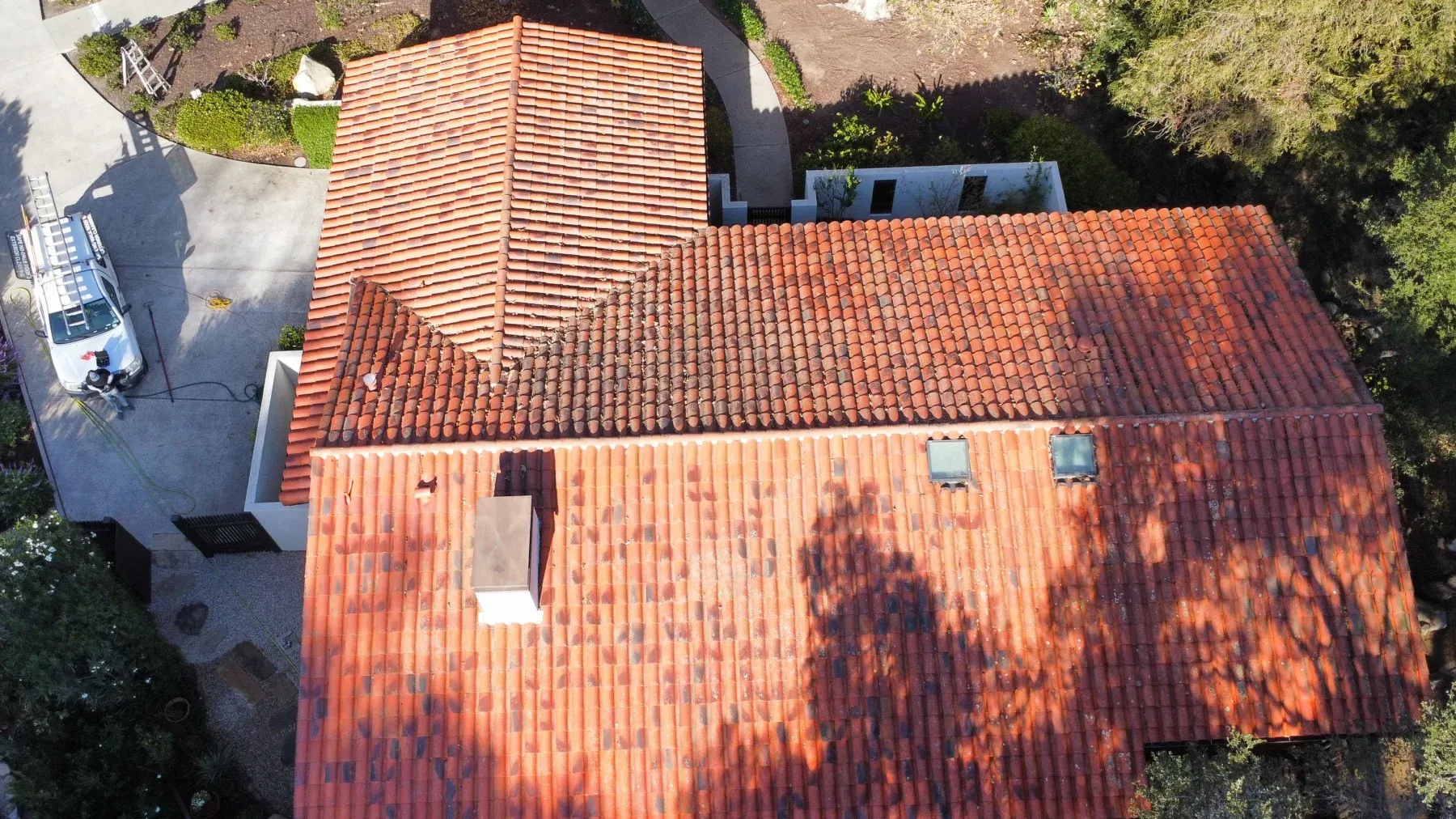 The same clay tile roof the next day after soft washing, bright terracotta again