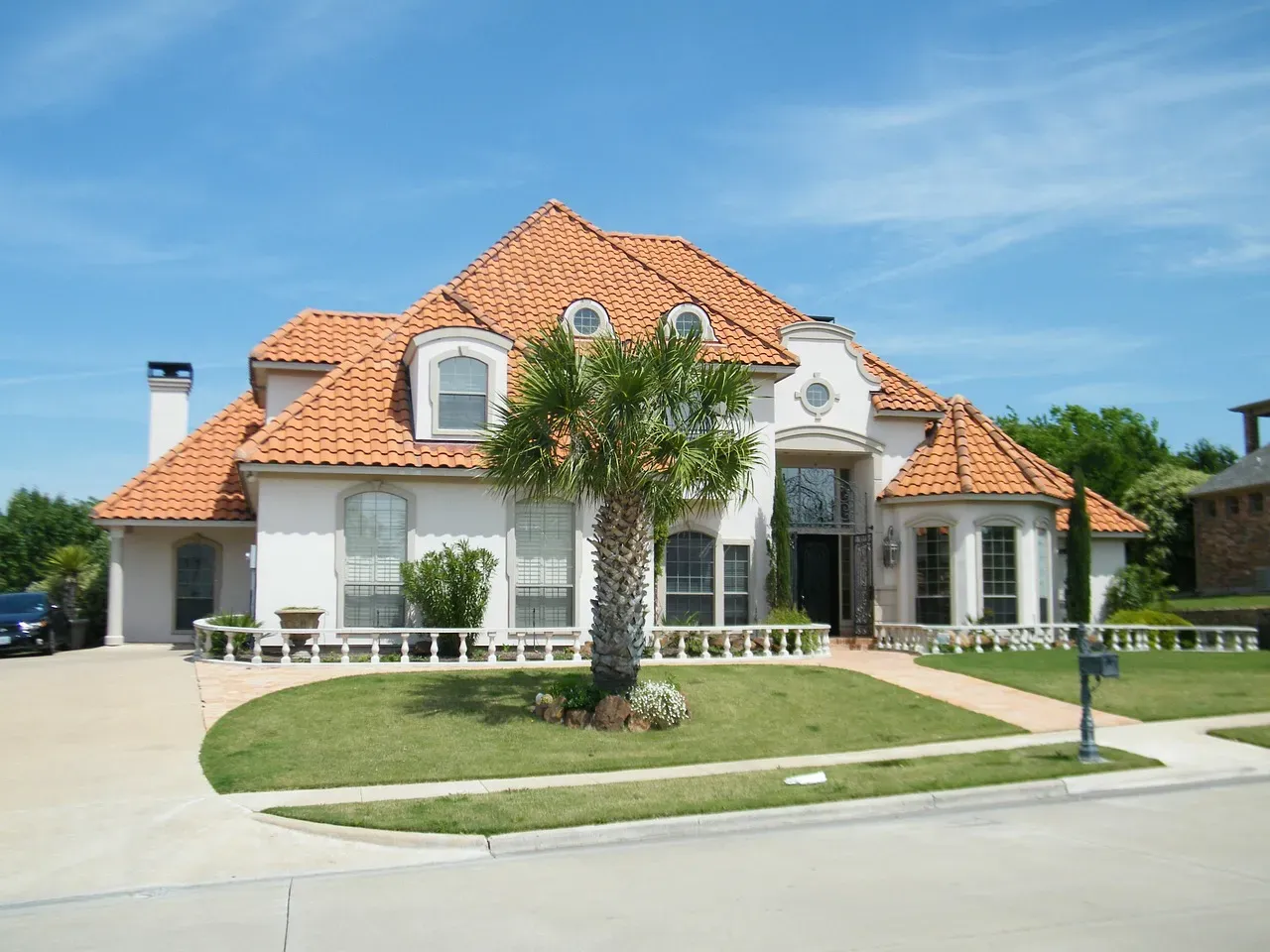 A freshly cleaned Santa Barbara home with a terracotta tile roof, white stucco walls, and manicured landscaping